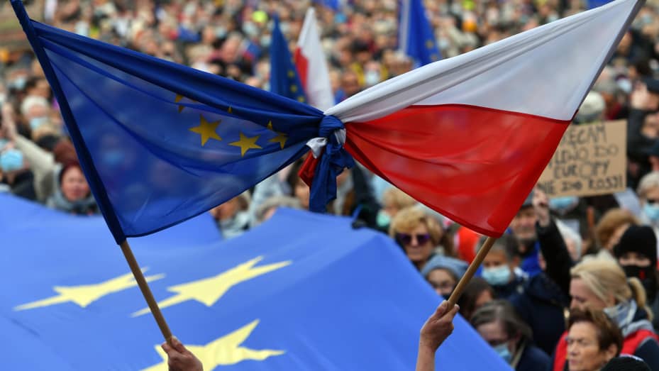 Demonstrators hold bound flags of the European Union and Poland during the demonstration.