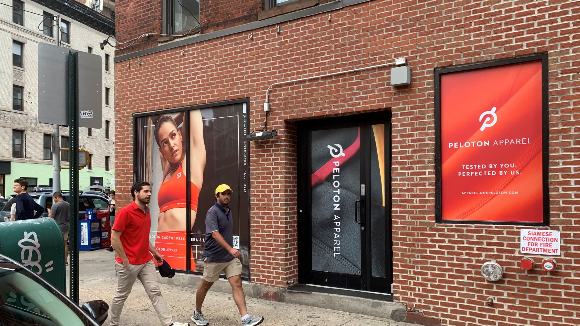 People walk by a storefront in New York City's SoHo neighborhood, where Peloton is advertising its apparel line.