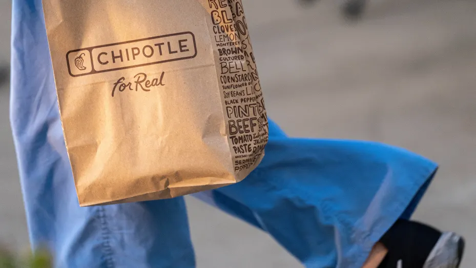 A customer carries a Chipotle bag in front of a restaurant in Santa Clara, California, U.S., on Tuesday, Oct. 19, 2021.