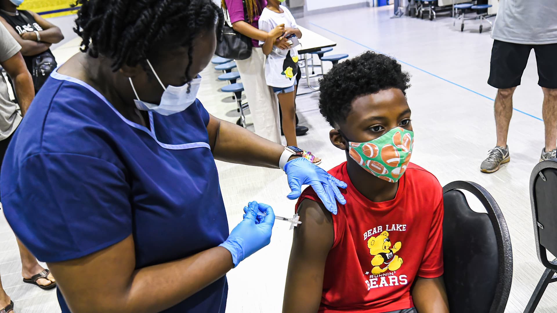 A nurse gives a boy a dose of the Pfizer vaccine at a COVID-19 vaccine clinic at Lyman High School in Longwood on the day before classes begin for the 2021-22 school year.