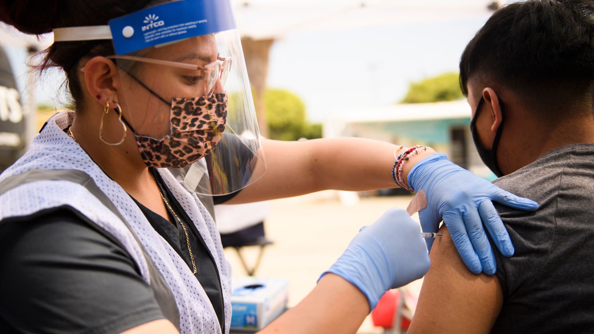 A 17-year-old receives a first dose of the Pfizer Covid-19 vaccine at a mobile vaccination clinic during a back to school event offering school supplies, Covid-19 vaccinations, face masks, and other resources for children and their families at the Weingart East Los Angeles YMCA in Los Angeles, California on August 7, 2021.