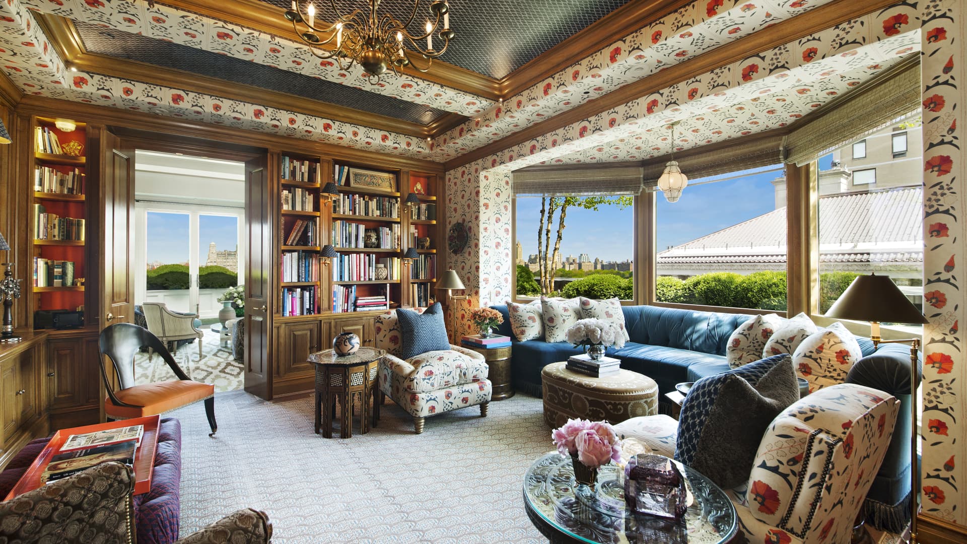 The wood-paneled library has upholstered walls with views of Central Park.