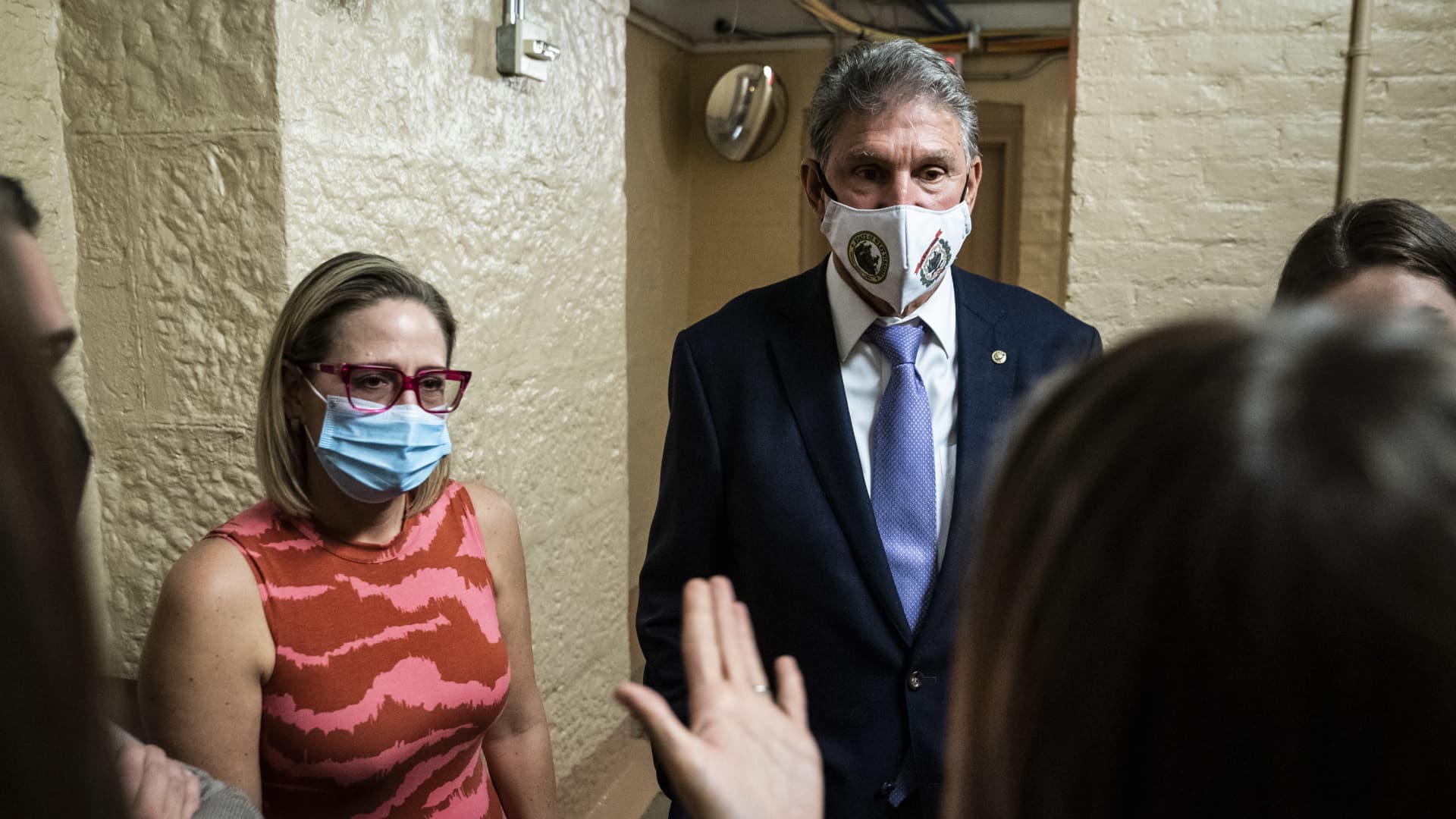 Sen. Kyrsten Sinema, D-Ariz., and Sen. Joe Manchin, D-W.Va., speak to a reporter after a private meeting between the two of them before a vote on Capitol Hill on Thursday, Sept. 30, 2021 in Washington, DC.