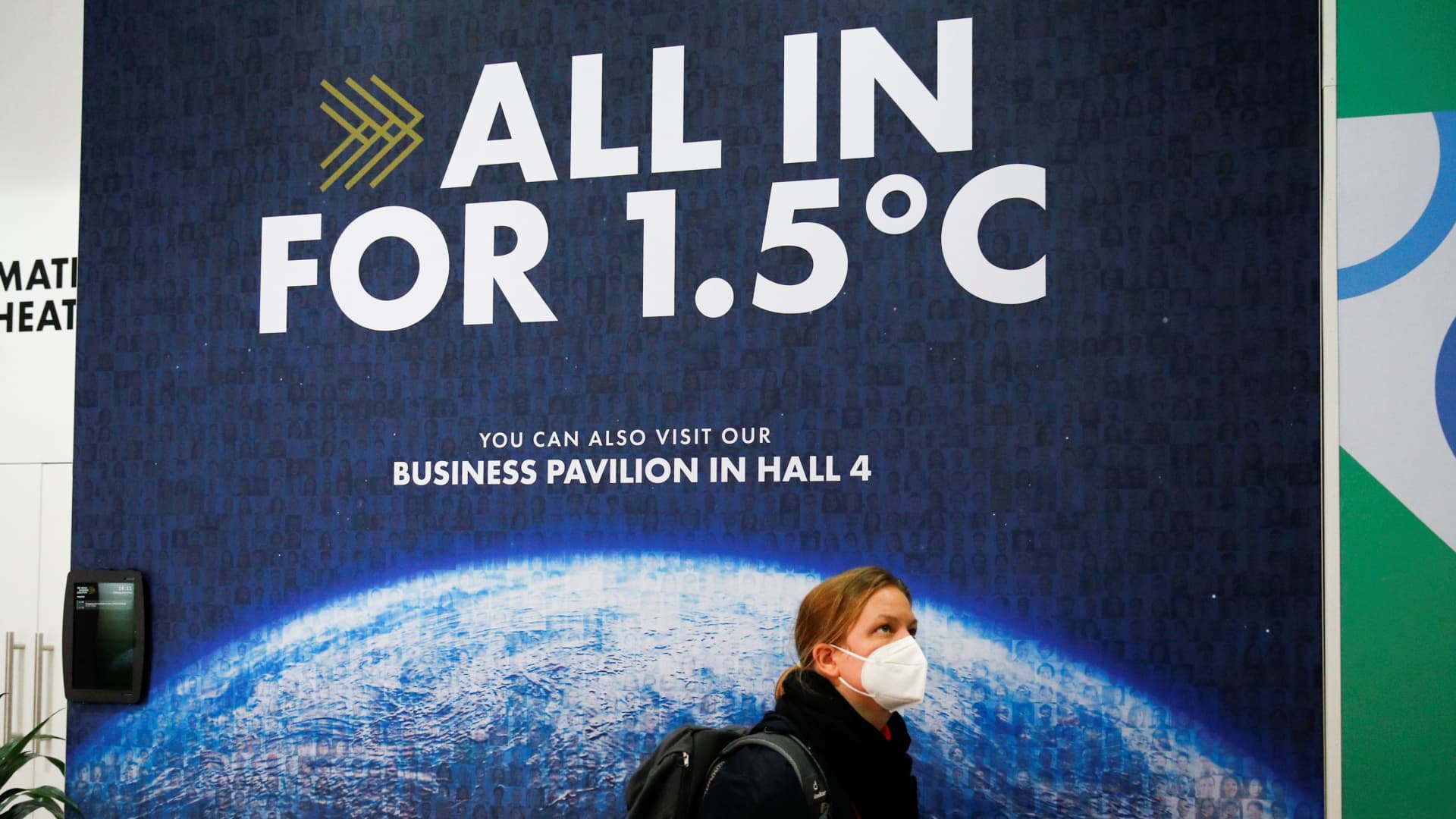 A delegate walks past a climate change poster at the UN Climate Change Conference (COP26) in Glasgow, Scotland, Britain, November 1, 2021.