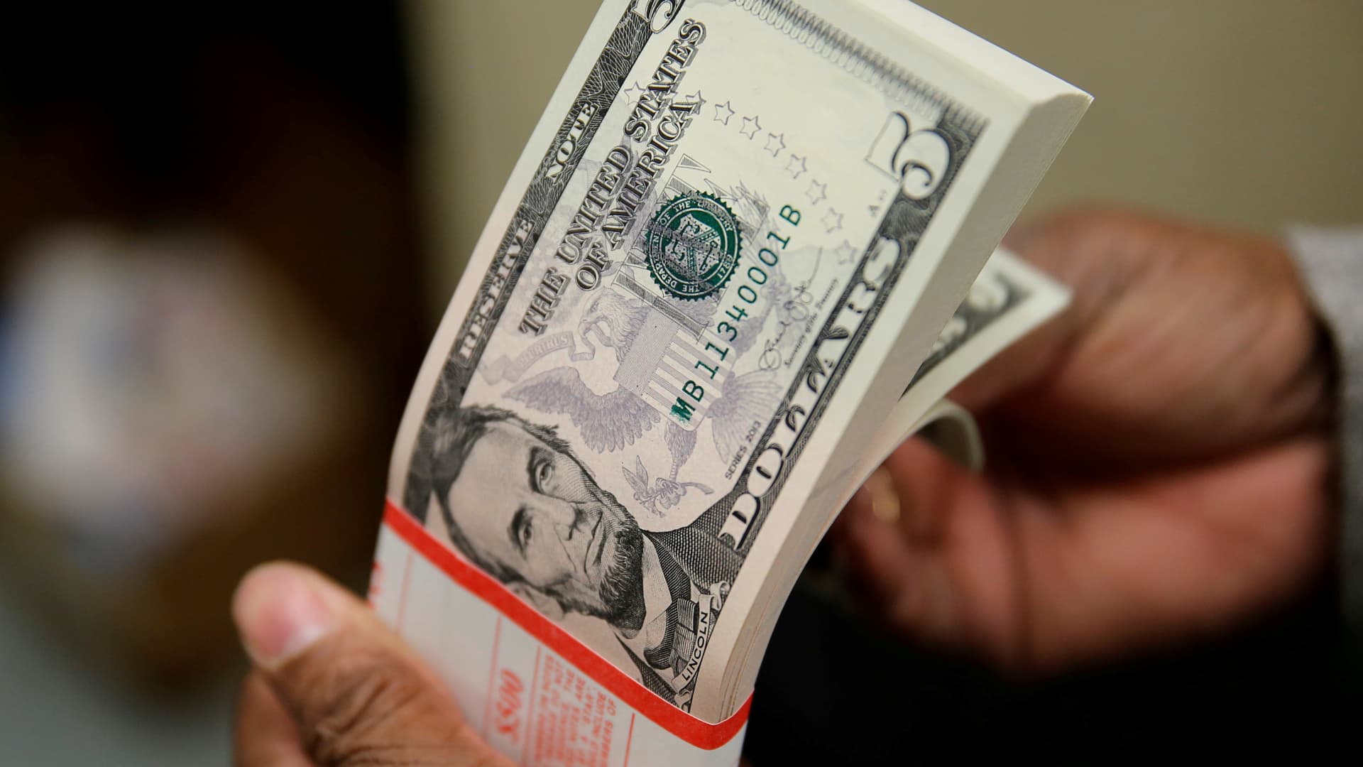 A packet of U.S. five-dollar bills is inspected at the Bureau of Engraving and Printing in Washington March 26, 2015.