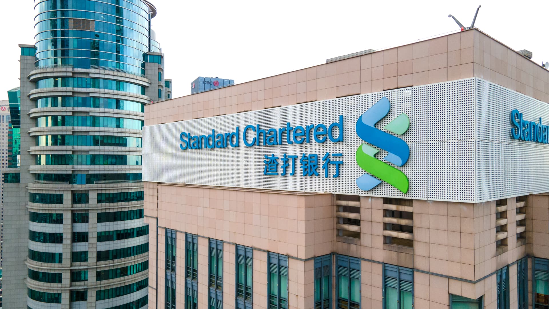 Standard Chartered Bank (SCB) in downtown, brand logo and office building in Shanghai.