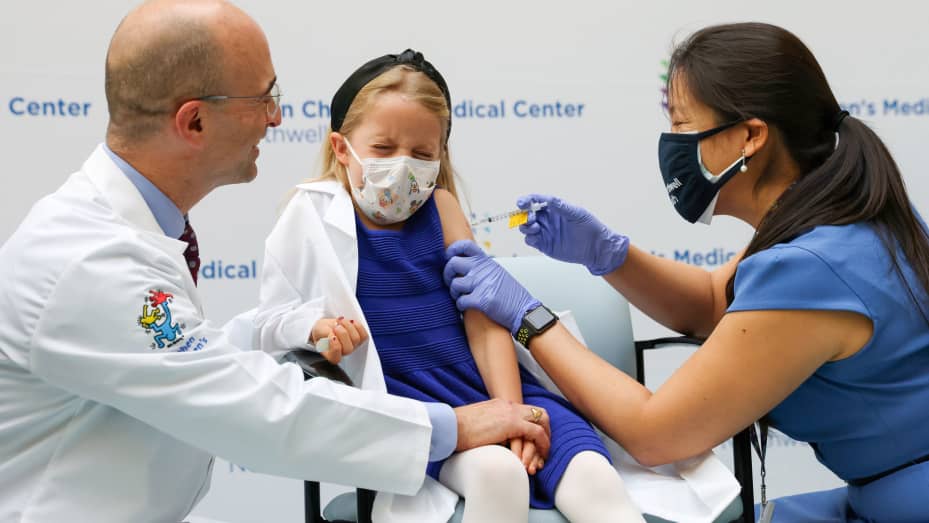 Nora Gossett, 7, reacts as she receives the Pfizer-BioNTech COVID-19 vaccine from Sophia Jan, MD, while her father Jeff Gossett, MD, holds her hand at Cohen Children's Medical Center as vaccines were approved for children aged 5-11, amid the coronavirus d