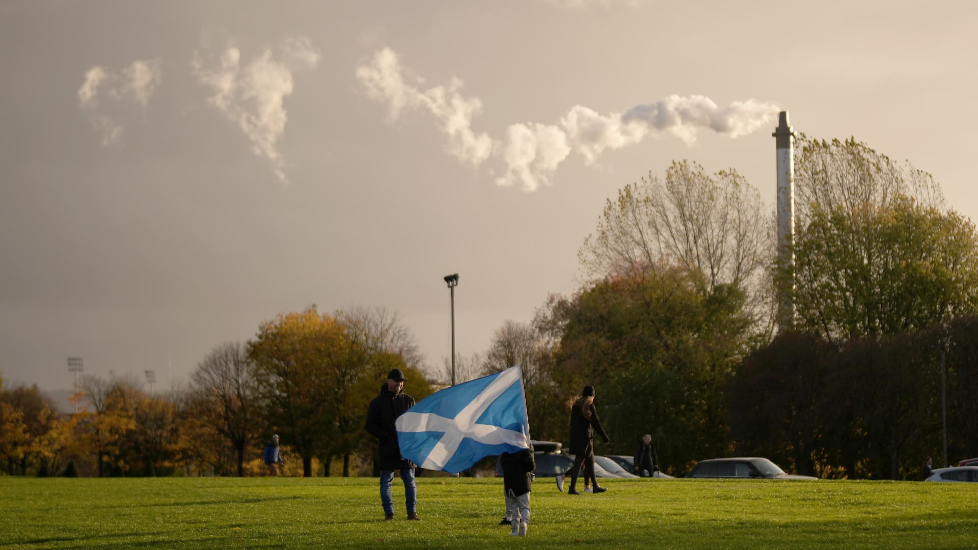 A child waves a saltire flag as pollution spills from a chimney at Glasgow Green as climate protestors gather for the Global Day of Action for Climate Justice march on November 06, 2021 in Glasgow, Scotland.