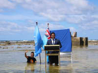 Tuvalu's Minister for Justice, Communication &amp; Foreign Affairs Simon Kofe gives a COP26 statement while standing in the ocean in Funafuti, Tuvalu November 5, 2021.