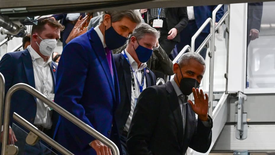 Former US President Barack Obama (R) waves as he walks with US Special Presidential Envoy for Climate, John Kerry, between sessions during the COP26 UN Climate Change Conference in Glasgow on November 8, 2021.