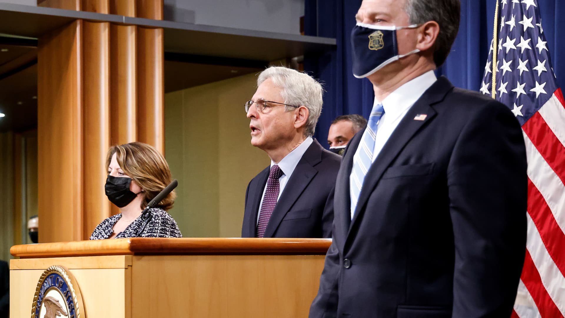 U.S. Attorney General Merrick Garland is flanked by Deputy Attorney General Lisa Monaco and FBI Director Christopher Wray as he announces charges against a suspect from Ukraine and a Russian national over a July ransomware attack on an American company, during a news conference at the Justice Department in Washington, November 8, 2021.