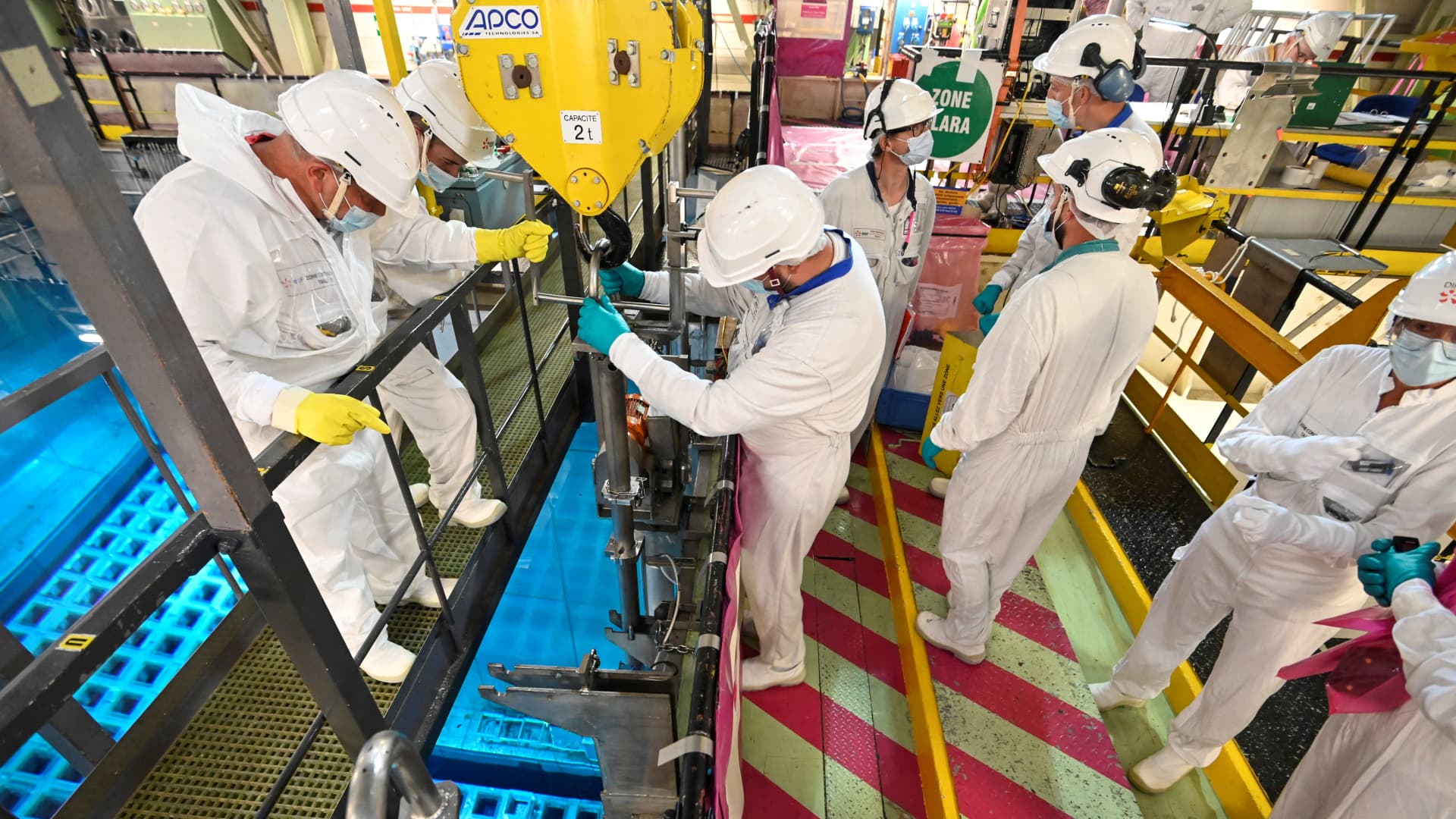 EDF employees remove a nuclear fuel bar from the storage poolat the Fessenheim nuclear power plant on June 21, 2021, in Fessenheim, eastern France.