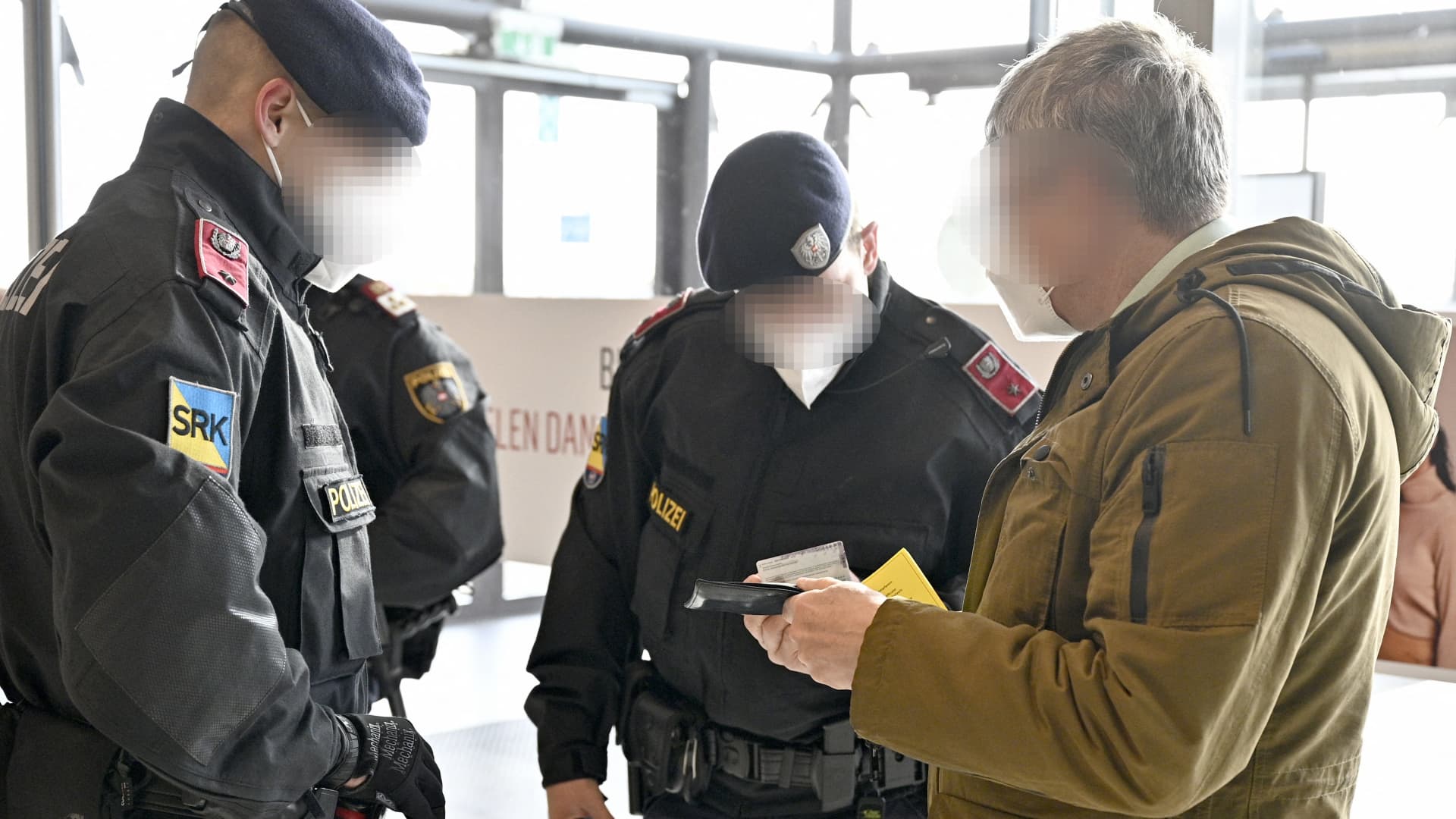 Austrian police officers check a man's identity and vaccination certificate during a control in Voesendorf, district Moedling, Austria, on November 16, 2021.