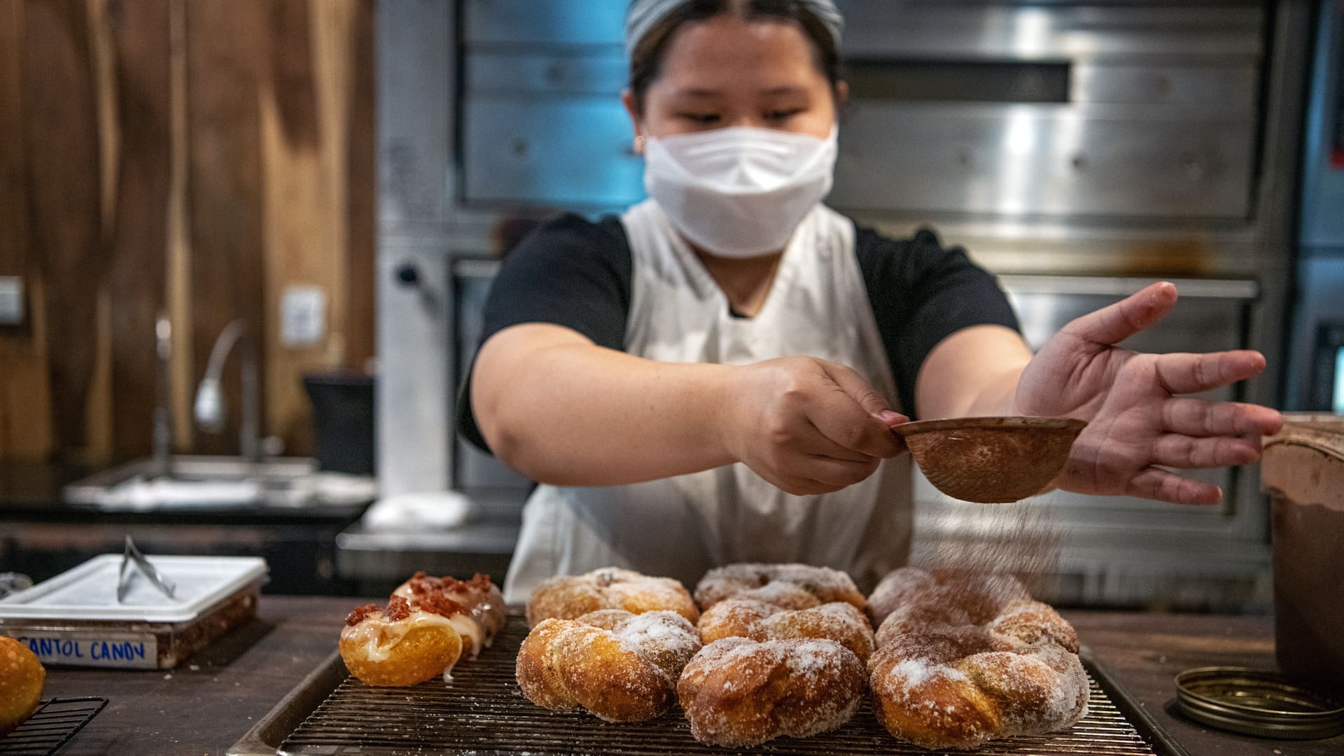 A baker in Panderya Toyo dusting bicho — a local version of beignets — with sugar and cacao.