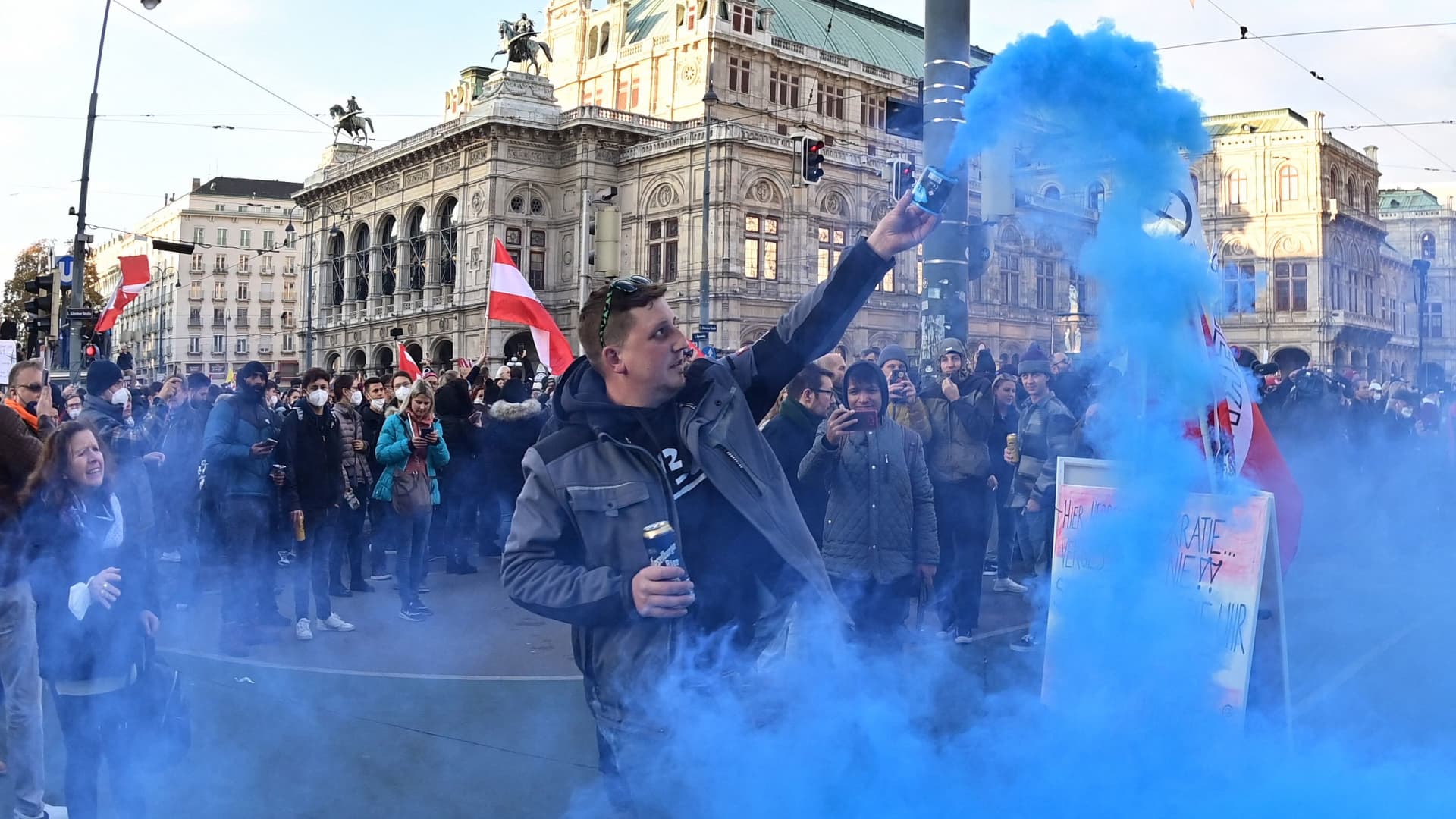 A demonstrator lights a smoke bomb during a rally held by Austria's far-right Freedom Party FPOe against the measures taken to curb the Covid pandemic, at Maria Theresien Platz square in Vienna, Austria on November 20, 2021.
