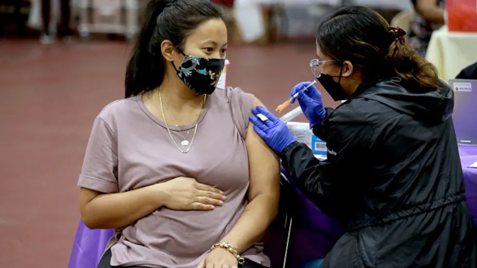 A woman receives a Pfizer vaccination booster shot at Eugene A. Obregon Park in Los Angeles.