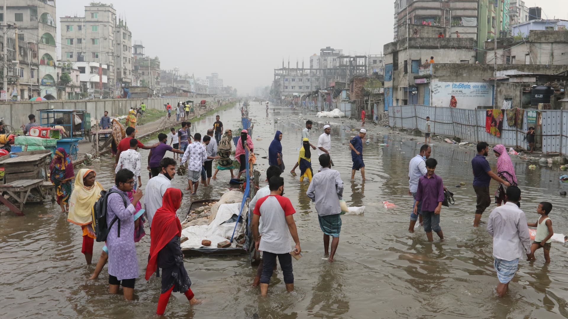 Dozens of people walk through water due to heavy rains causing flooding in Dhaka, Bangladesh on October 7, 2021.