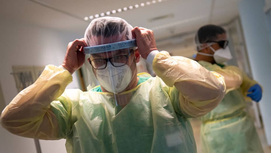 Senior doctor Thomas Marx puts on his personal protective gear (PPE) before he enters the room of a patient infected with the novel coronavirus (Covid-19) in an intensive care unit (ICU) at the hospital in Freising, southern Germany.