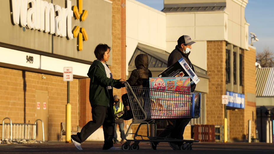 A family of Black Friday shoppers walks out of Walmart with a full shopping cart on November 26, 2021 in Westminster, Colorado.