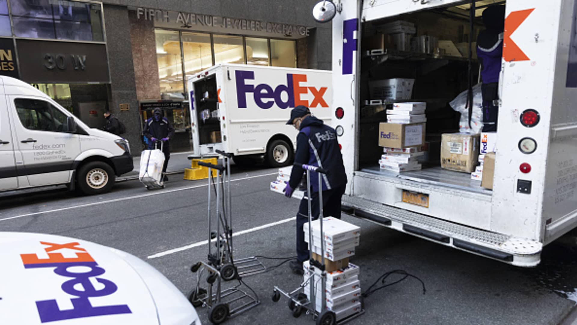 A FedEx Corp. courier prepares packages for delivery during Cyber Monday in the Diamond District neighborhood of New York, U.S., on Monday, Nov. 29, 2021.