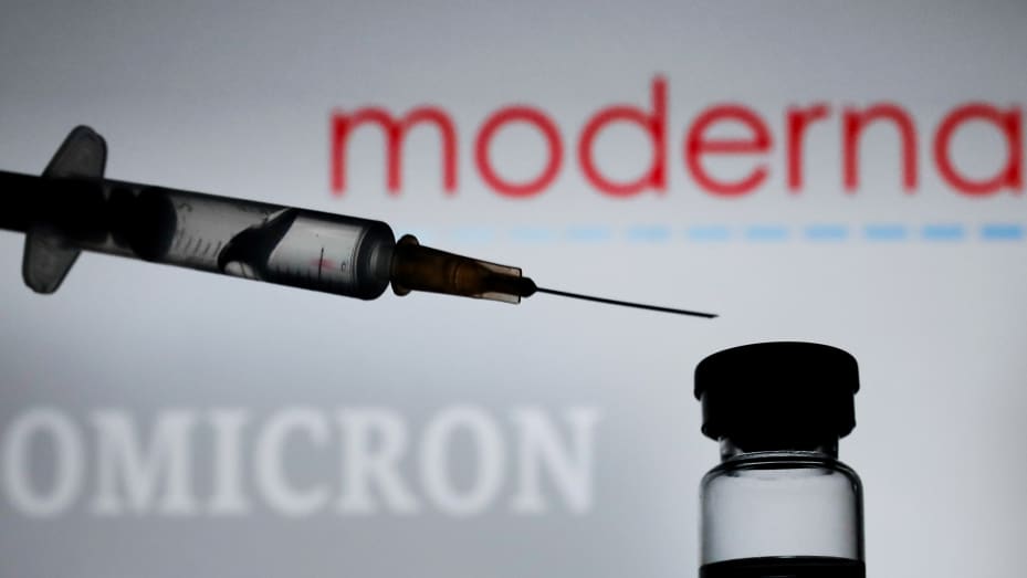 Medical syringe is seen with Moderna logo and 'omicron' sign displayed in the background in this illustration photo taken in Krakow, Poland on November 29, 2021.