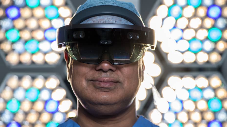 Surgeon Shafi Ahmed poses for a photograph wearing a Microsoft HoloLens headset inside his operating theater at the Royal London Hospital on Thursday, Jan. 11, 2018.