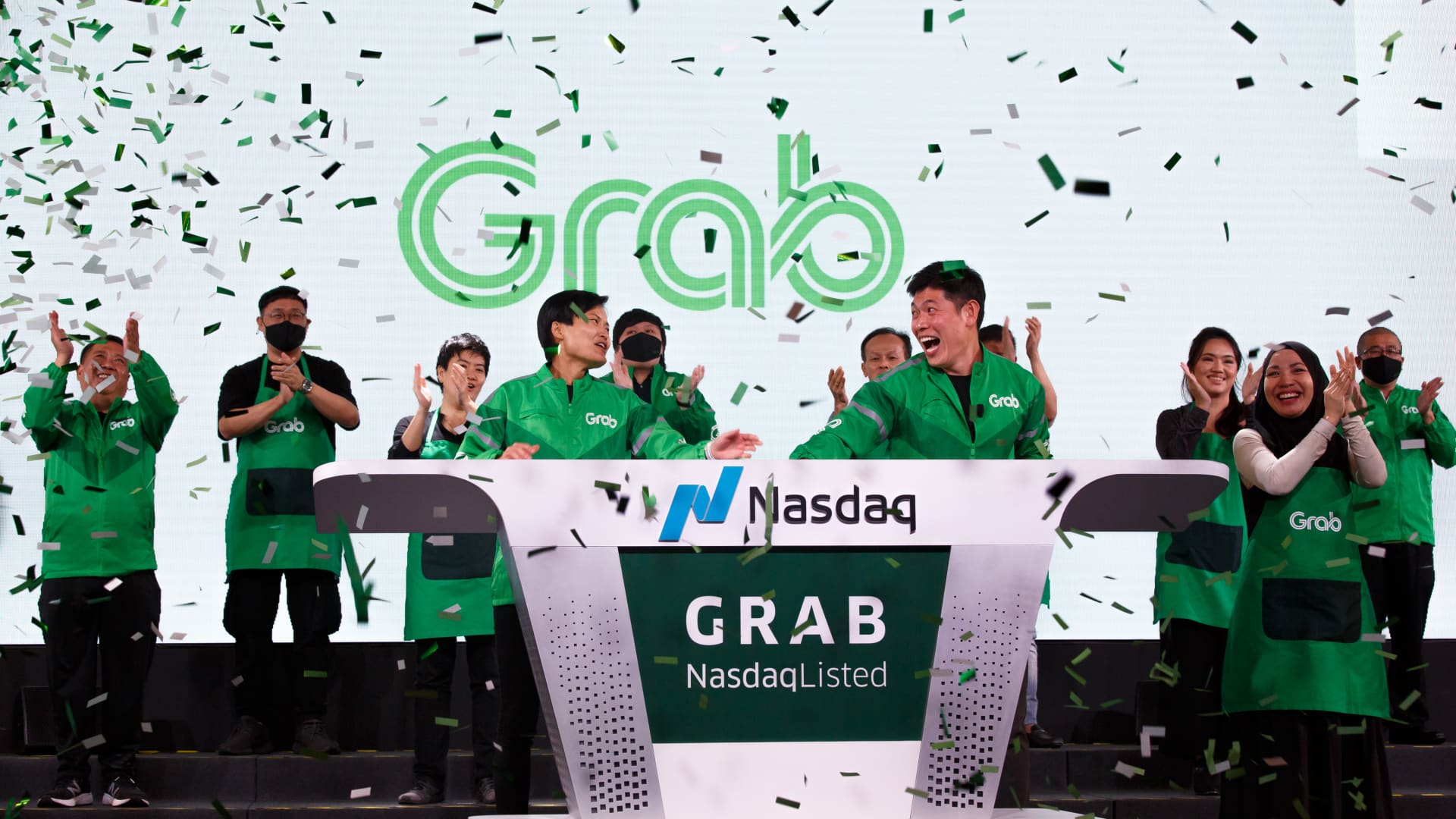 Anthony Tan, chief executive officer of Grab Holdings Inc., center right, and Tan Hooi Ling, co-founder of Grab Holdings Inc., celebrate on stage during a bell-ringing ceremony as Grab begins trading on the Nasdaq, in Singapore, on Thursday, Dec. 2, 2021.