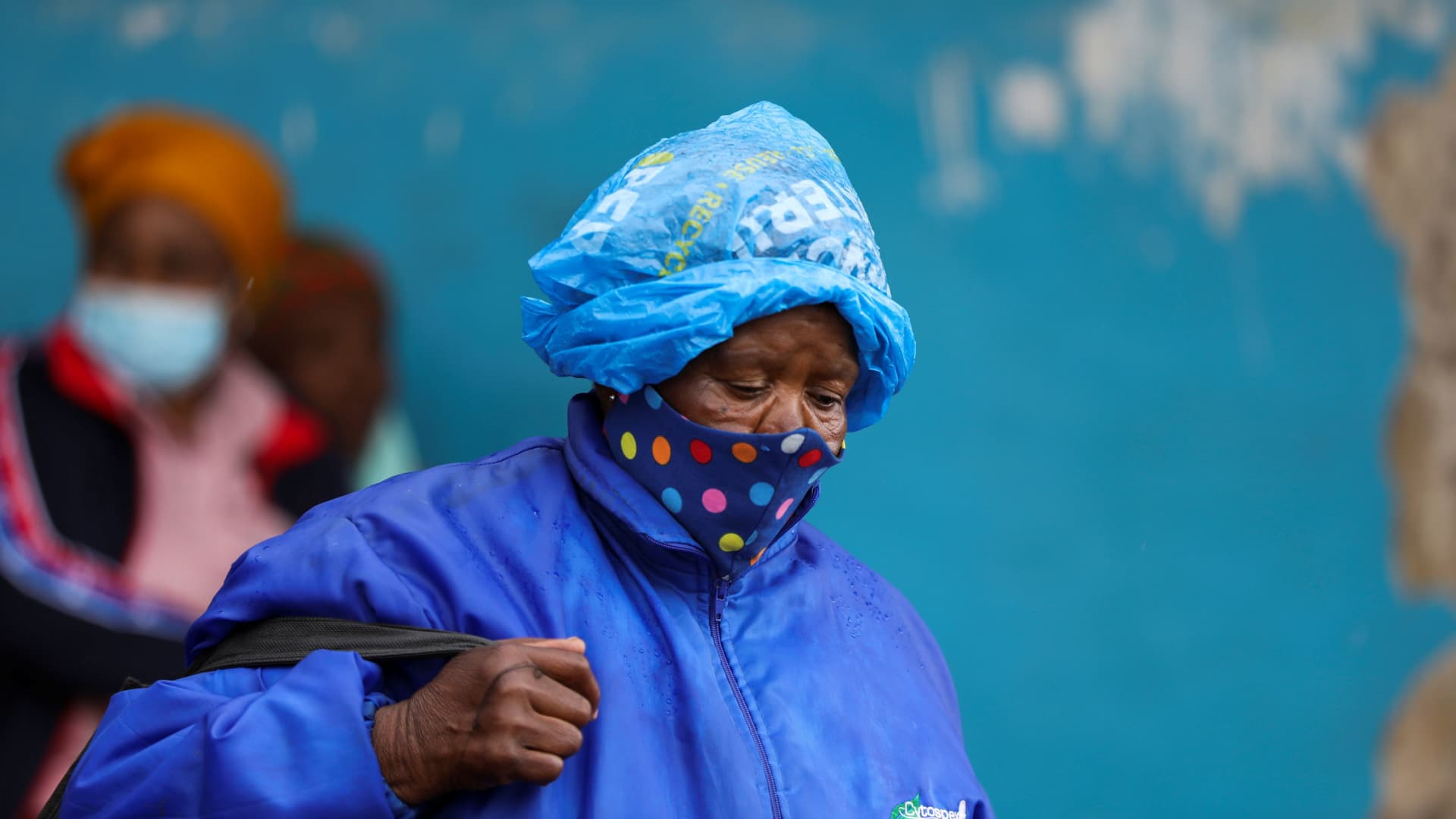 A woman wearing a protective face mask against the coronavirus disease (COVID-19) and a plastic bag on her head to protect from the rain looks on, as the new Omicron coronavirus variant spreads, at Tsomo, a town in the Eastern Cape province of South Africa, December 2, 2021.