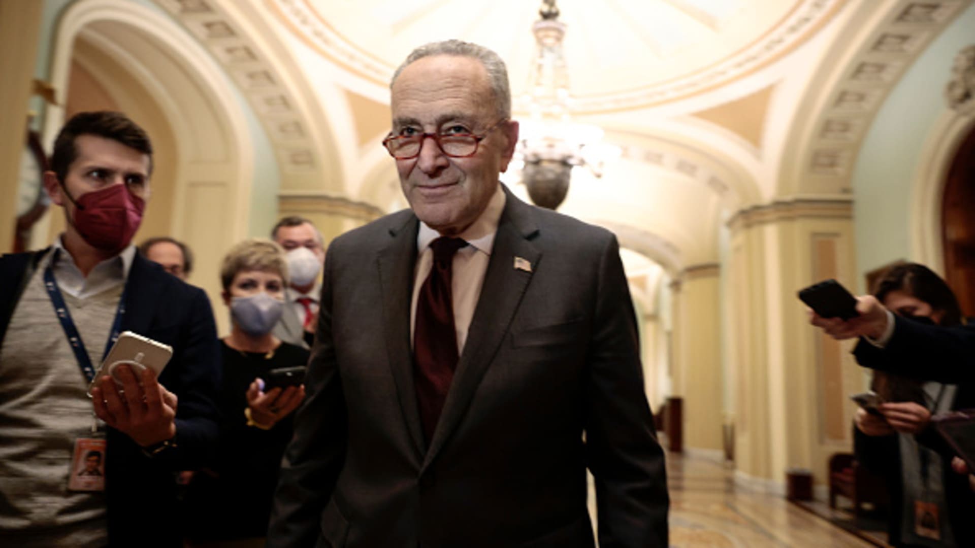 WASHINGTON, DC - DECEMBER 07: U.S. Senate Majority Leader Chuck Schumer (D-NY) walks away from reporters after speaking with them outside the Senate Chambers of the Capitol on December 07, 2021 in Washington, DC. Schumer updated reporters on an agreement being made with Senate Republicans to pass legislation to lift the debt ceiling.