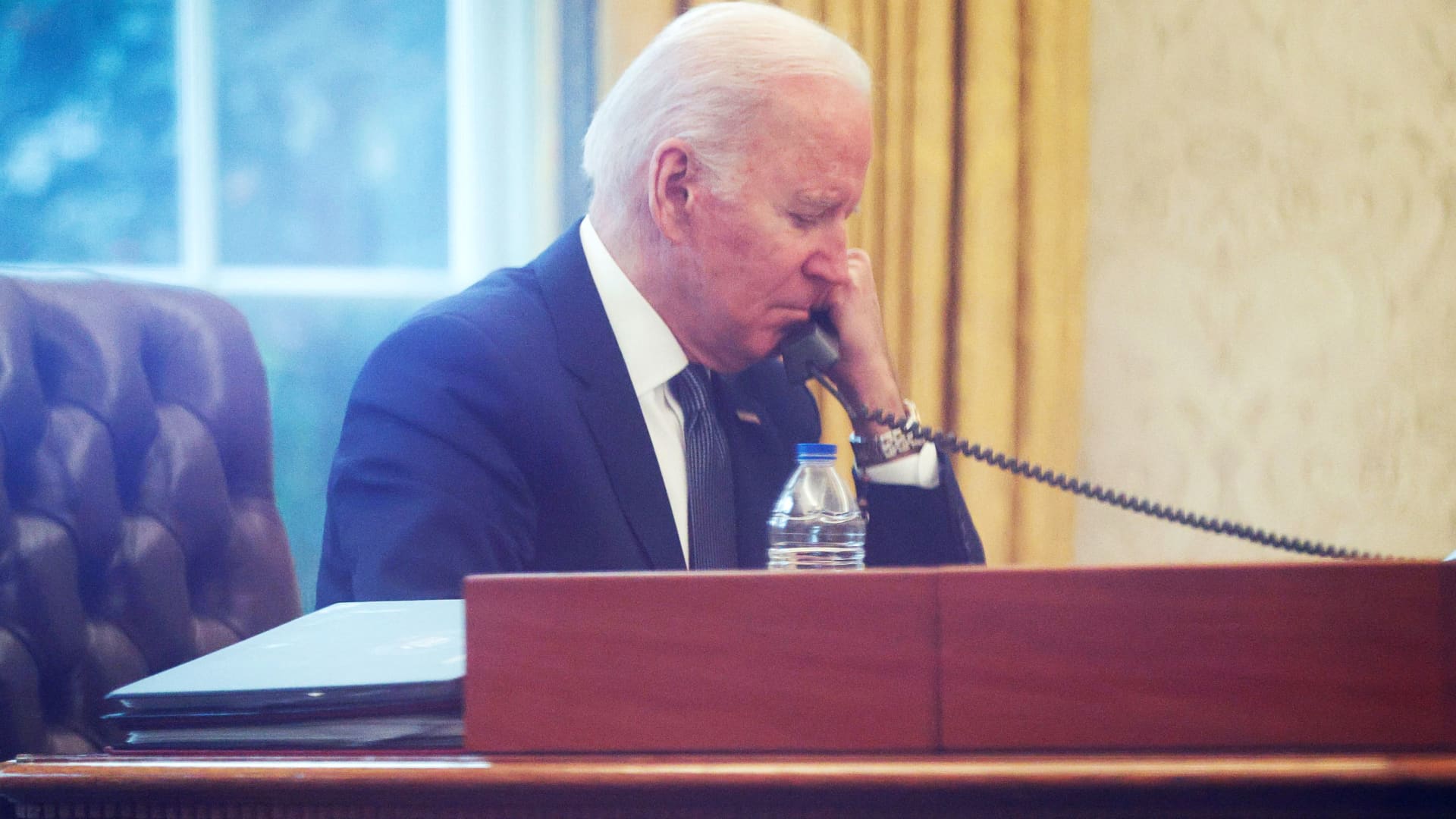 U.S. President Joe Biden is seen through a window in the Oval Office as he speaks by phone with Ukraine's President Volodymyr Zelensky at the White House in Washington, December 9, 2021.