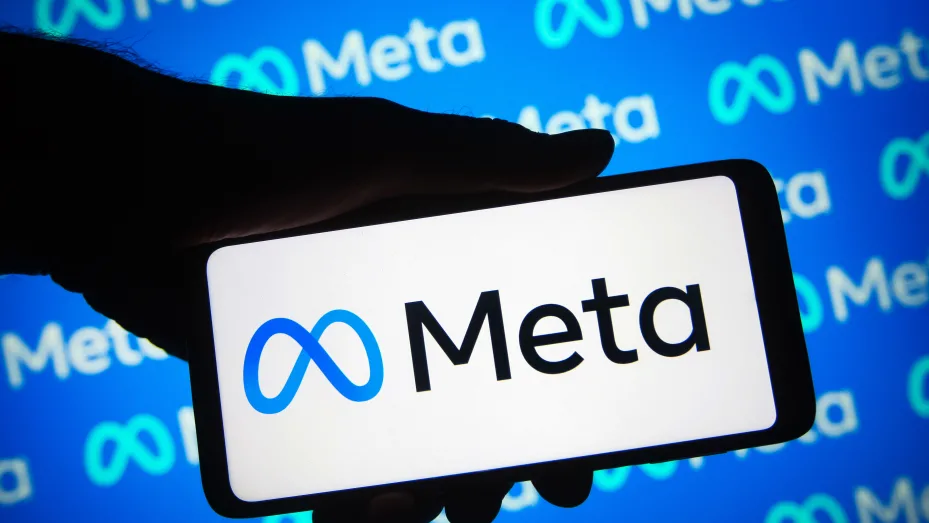 a Meta logo is seen on a smartphone and in the background.