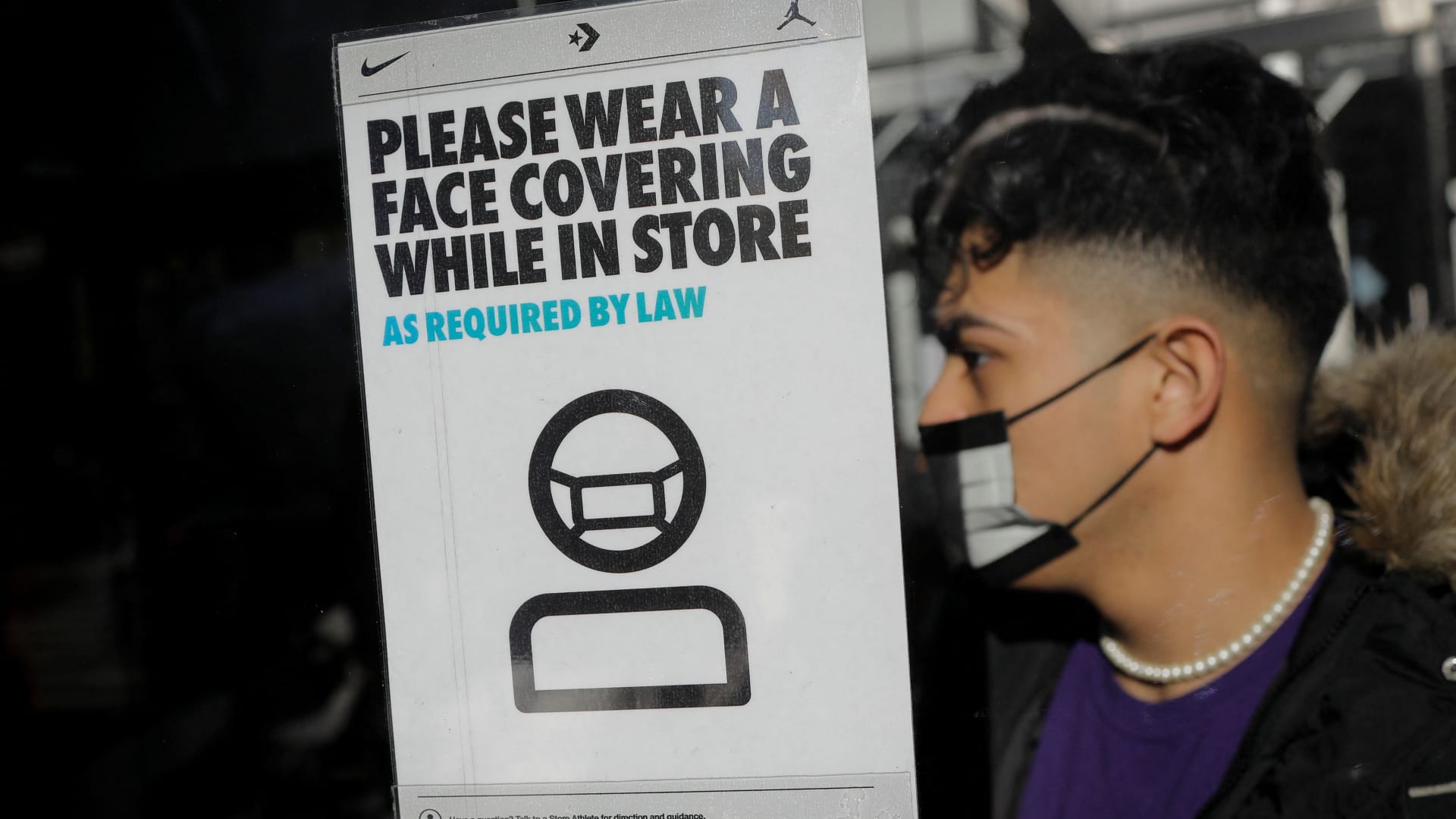 A shopper wears a protective face mask as he enters a store as new New York State indoor masking mandates went into effect amid the spread of the coronavirus disease (COVID-19) in New York City, New York, U.S., December 13, 2021.