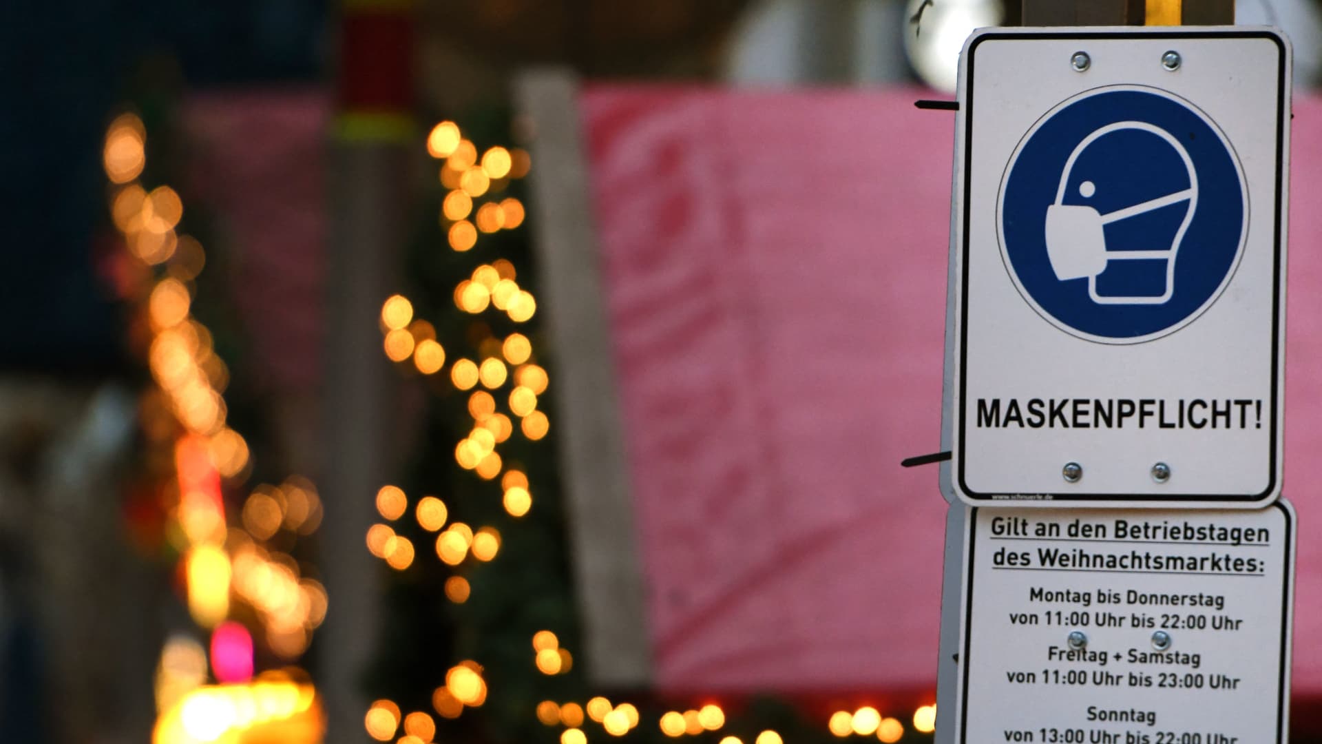 A sign indicating an obligation to wear face masks is seen at the Christmas market in the city of Duisburg, western Germany on November 29, 2021.
