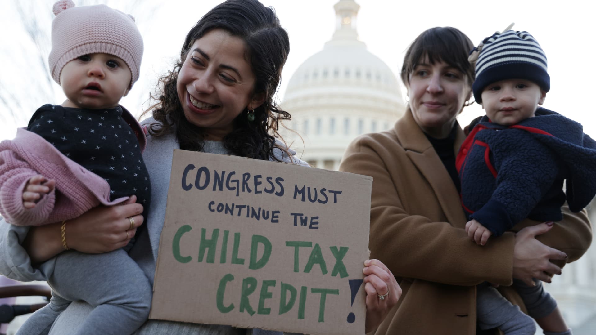Washington, D.C.-area residents Cara Baldari and her 9-month-old daughter Evie (left) and Sarah Orrin-Vipond and her 8-month-old son Otto (right), join a rally in front of the U.S. Capitol on Dec. 13, 2021.