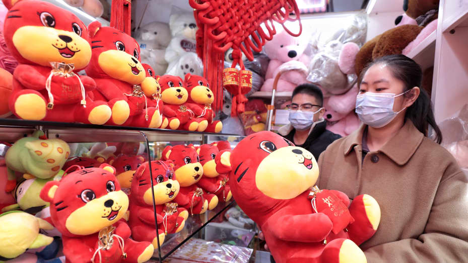 A customer buys zodiac decorations for the Year of the Tiger at a market in Zhangjiagang city, East China's Jiangsu province, Dec. 10, 2021.