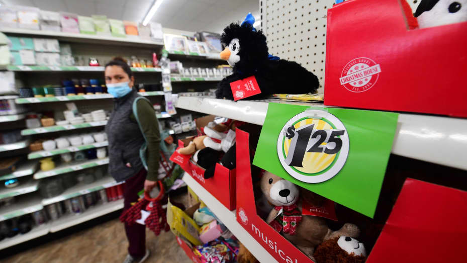 A shopper walks by a sign displaying $1.25 price, posted on the shelves of a Dollar Tree store in Alhambra, California, December 10, 2021. The store is known for its $1 items, but due to inflation raised prices to $1.25.