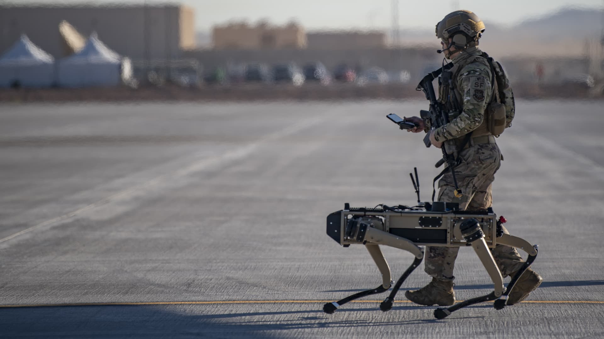 Tech. Sgt. John Rodiguez, 321st Contingency Response Squadron security team, patrols with a Ghost Robotics Vision 60 prototype at a simulated austere base during the Advanced Battle Management System exercise on Nellis Air Force Base, Nev., Sept. 3, 2020.