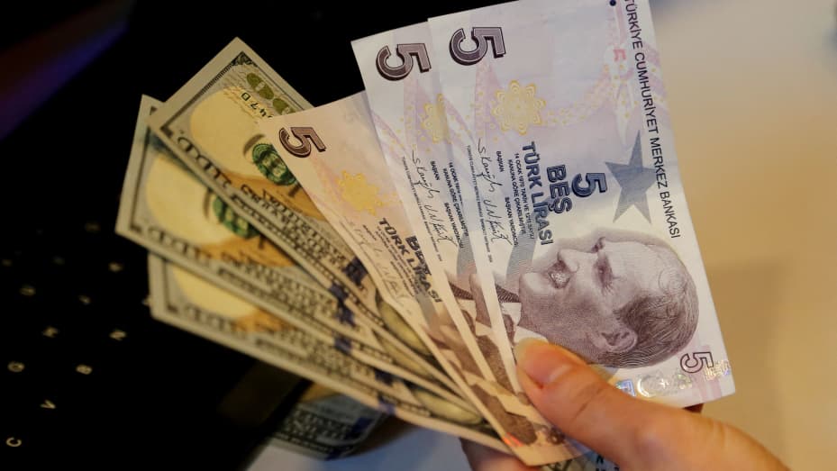 Un cambista sostiene billetes de liras turcas y dólares estadounidenses en una oficina de cambio de divisas en Ankara, Turquía, el 16 de diciembre de 2021.