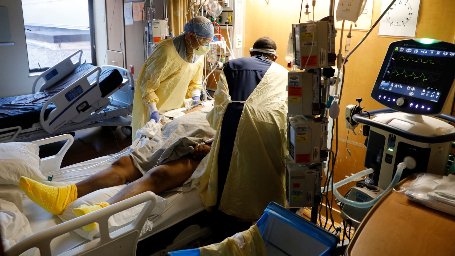 US Army Critical Care Nurse, Captain Edward Rauch Jr. (L), turns a Covid-19 patient on a ventilator at Beaumont Hospital in Dearborn, Michigan on December, 17, 2021.