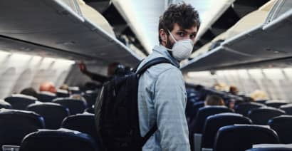 Wear a mask if you're sick and must travel, flight attendant union chief says