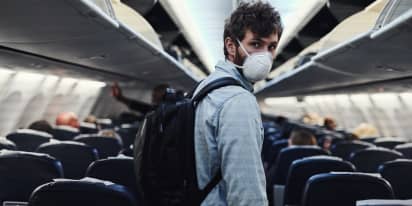 Wear a mask if you're sick and must travel, flight attendant union chief says