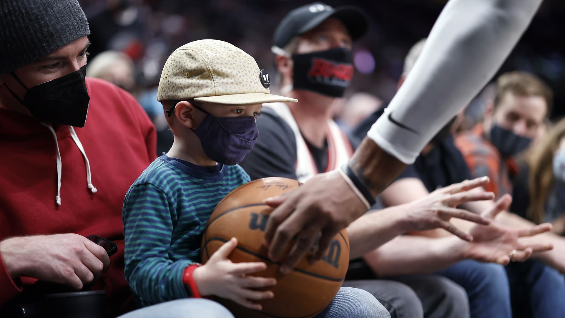 Marcus Morris Sr. # 8 of the Los Angeles Clippers hands a ball to a young fan during the first half against the Portland Trail Blazers at Moda Center on December 06, 2021 in Portland, Oregon.
