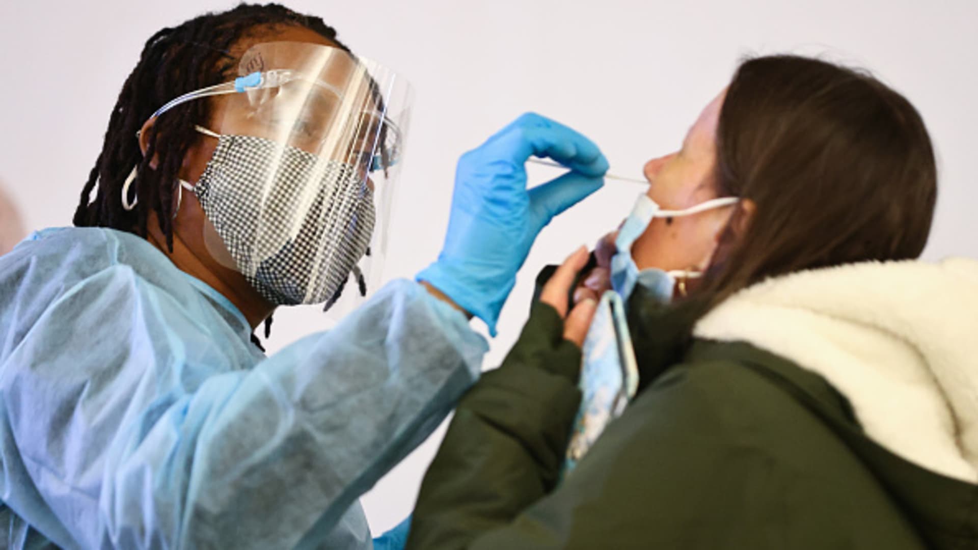 Merline Jimenez (L) administers a COVID-19 nasopharyngeal swab to a person at a testing site located in the international terminal at Los Angeles International Airport (LAX) amid a surge in omicron variant cases on December 21, 2021 in Los Angeles, California.
