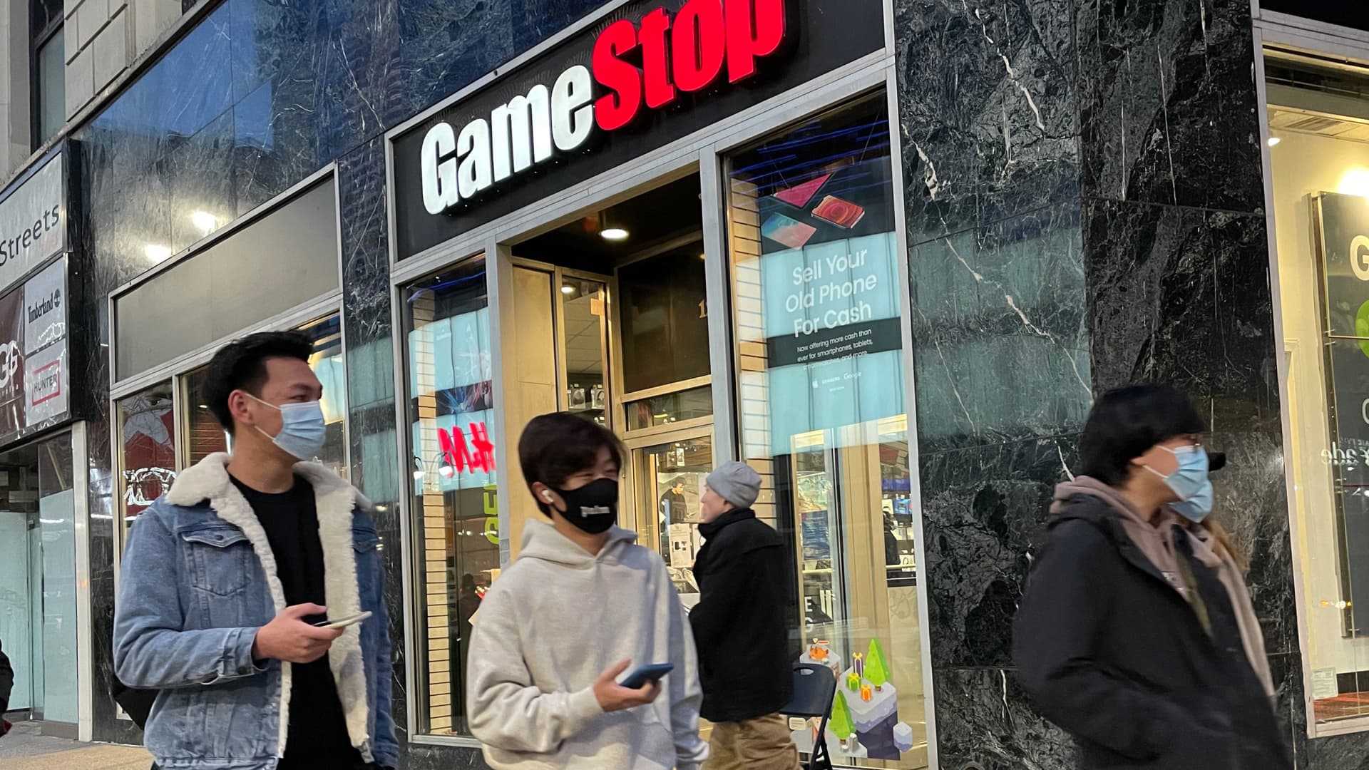 Pedestrians pass in front of a GameStop retail store in New York, December 23, 2021.