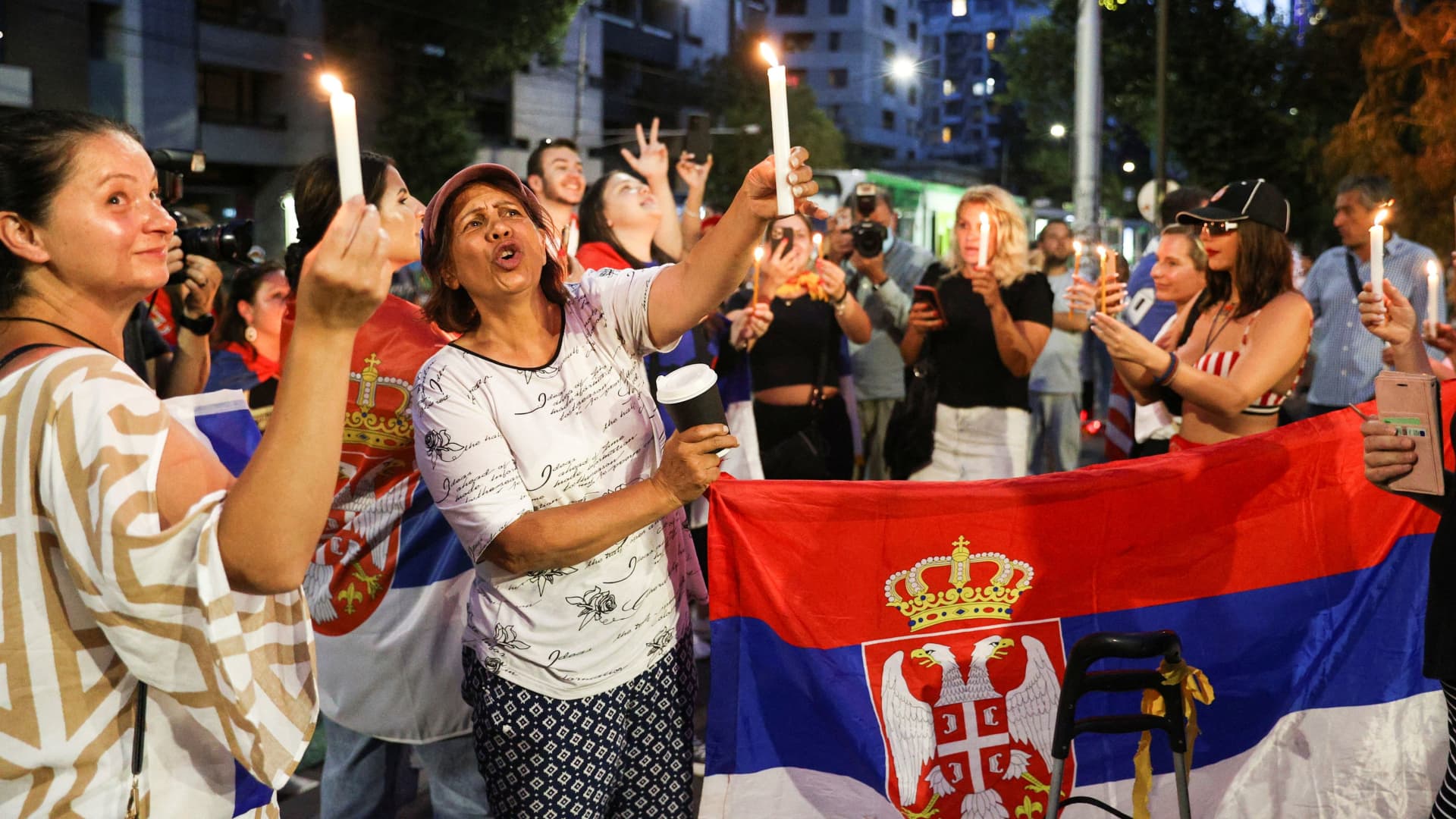 Supporters of Serbian tennis player Novak Djokovic rally outside the Park Hotel, where the star athlete is believed to be held while he stays in Australia, in Melbourne, Australia, January 6, 2022.