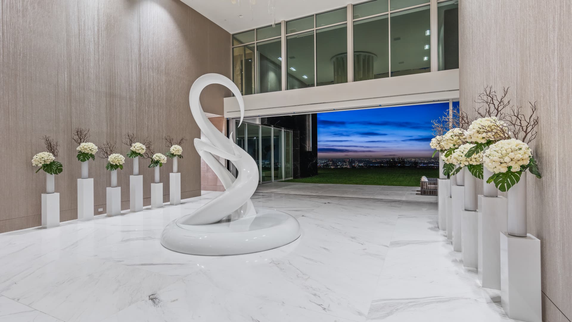 The mansion's foyer includes 25-foot ceilings, a large serpent-like sculpture and panoramic views of downtown LA.