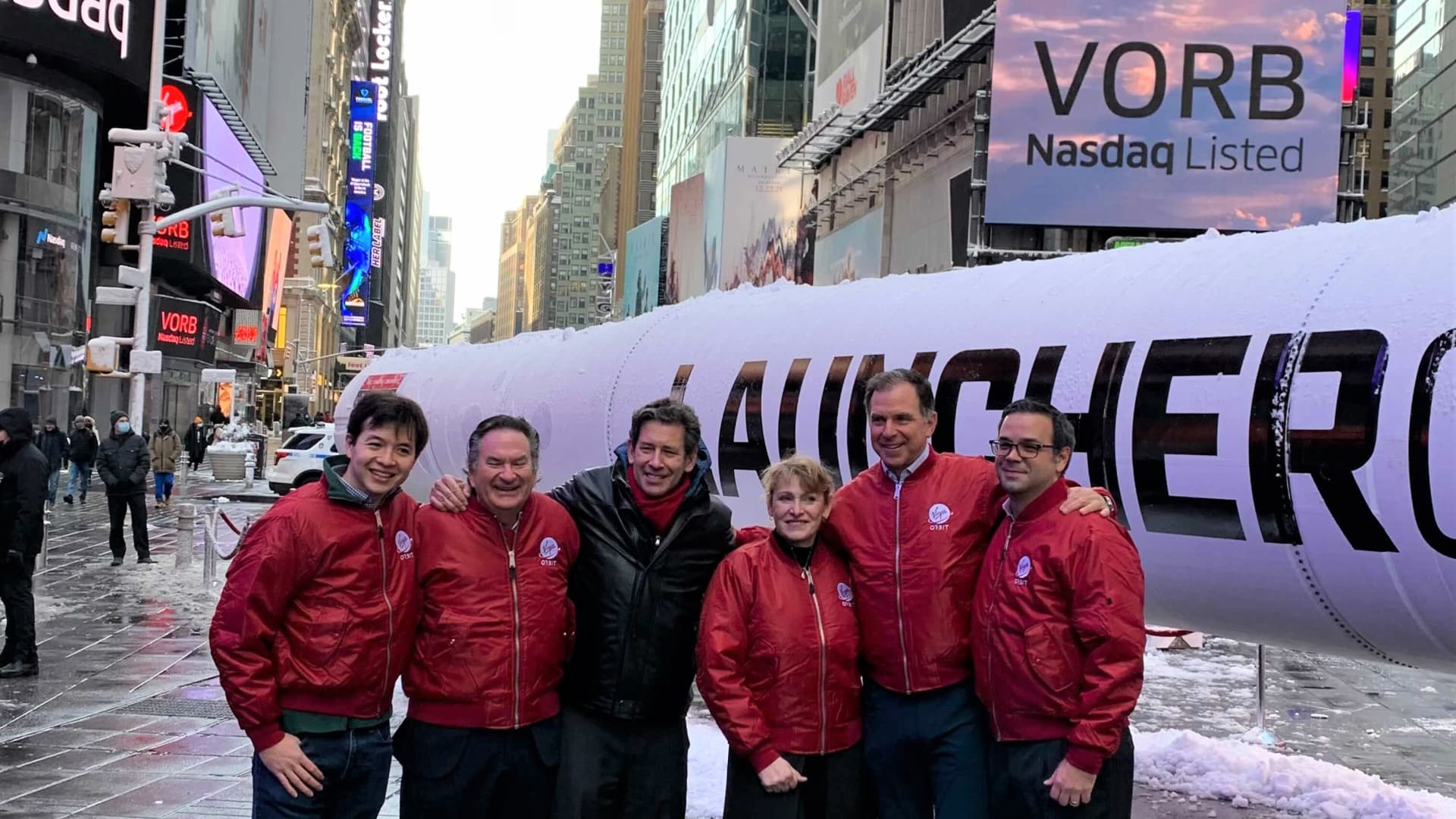 Virgin Orbit CEO Dan Hart (center, black jacket) stands with company executives in Times Square, New York.