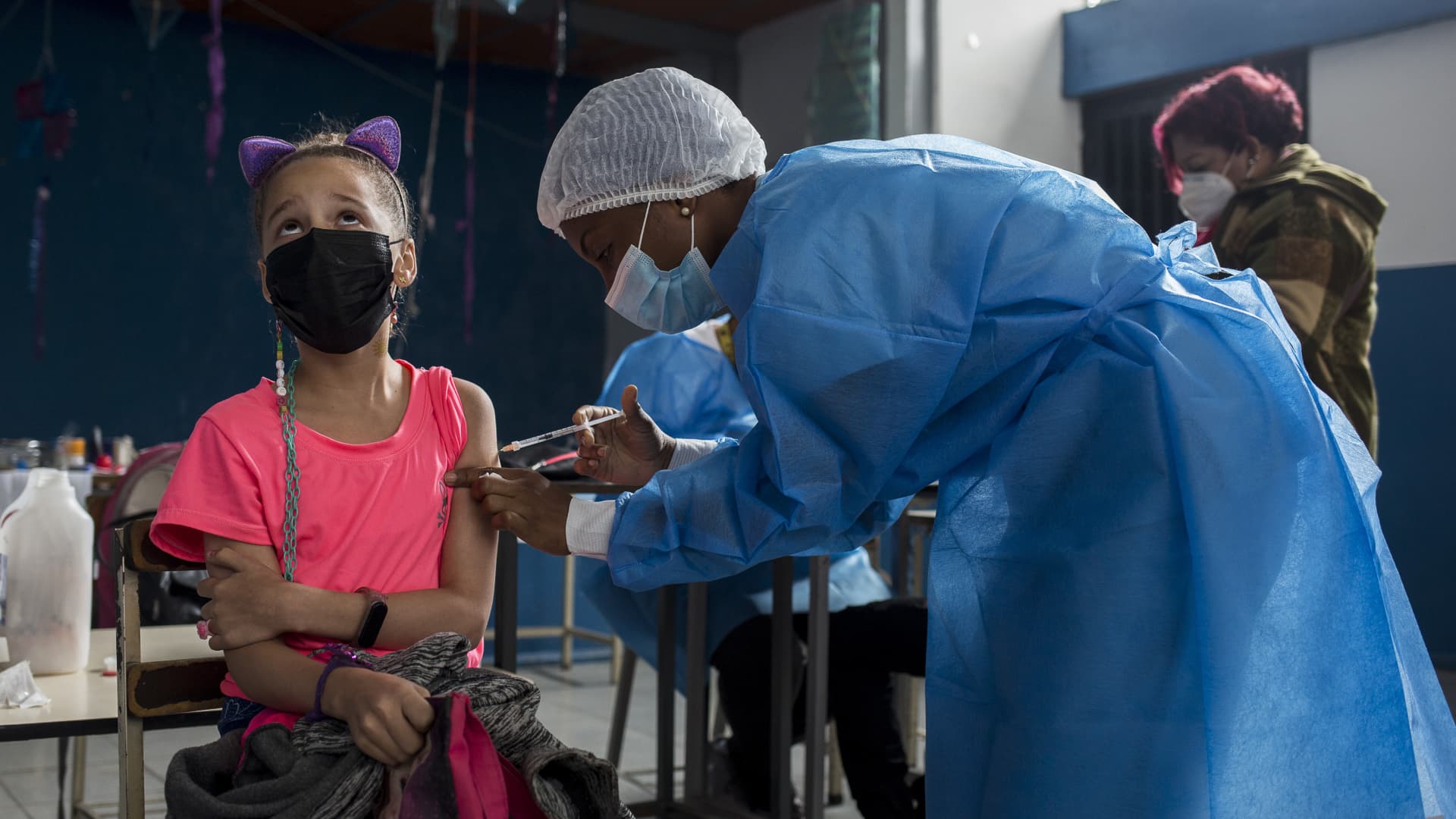 Students, who are accompanied by their mother, are being vaccinated with a dose of the Soberana 2 vaccine against the new coronavirus disease, COVID-19, developed in Cuba, at the Bolivar educational center in Caracas, Venezuela on December 13, 2021.