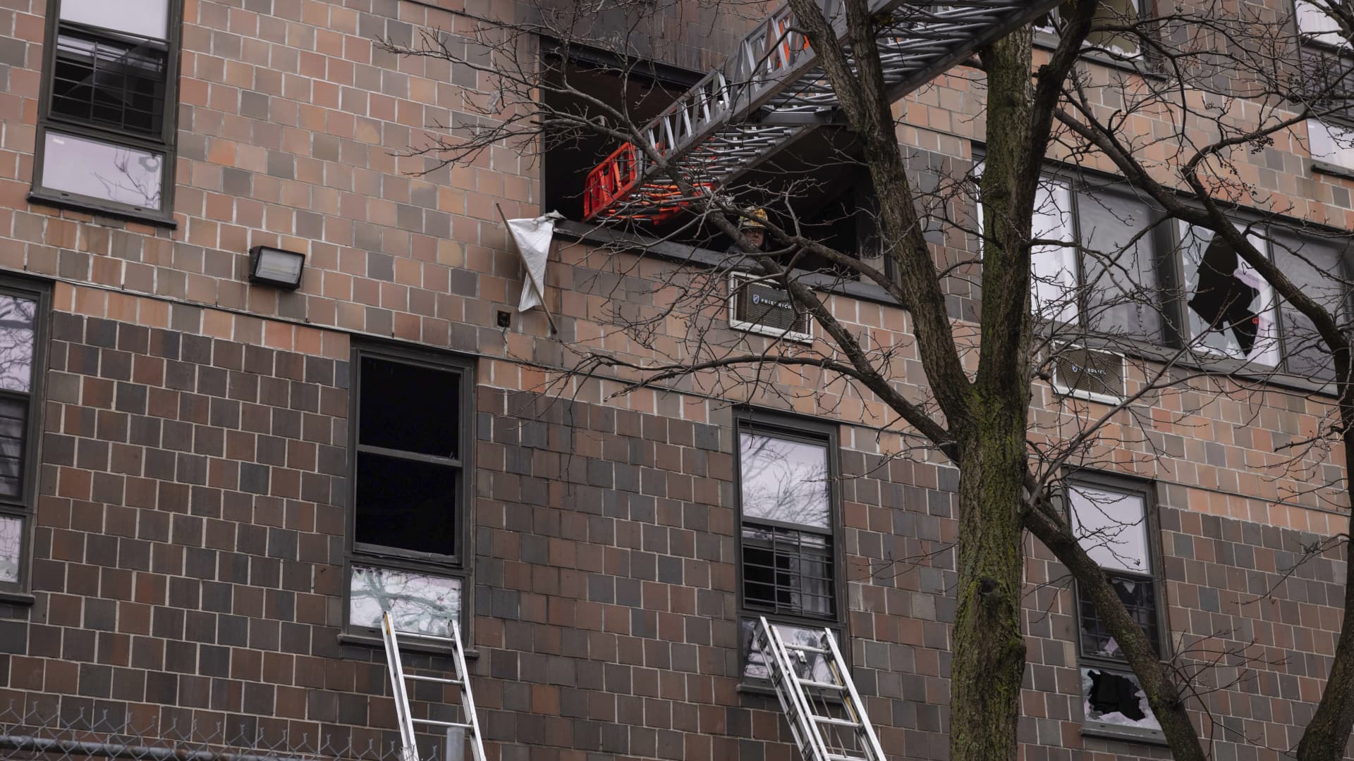 Ladders are seen erected beside the apartment building in the Bronx after a fire occurred on Sunday, Jan. 9, 2022, in New York.