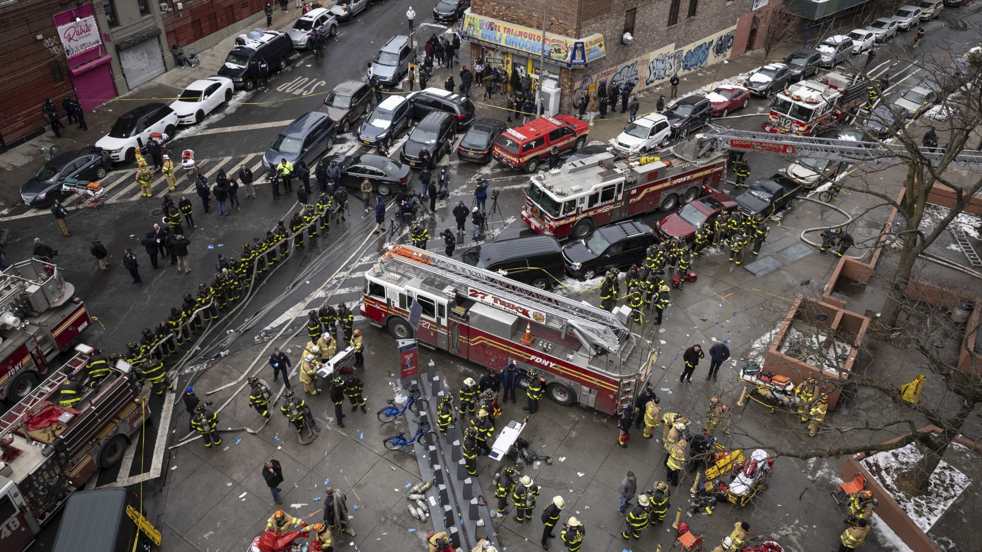 Firefighters work outside an apartment building after a fire in the Bronx, Sunday, Jan. 9, 2022, in New York.